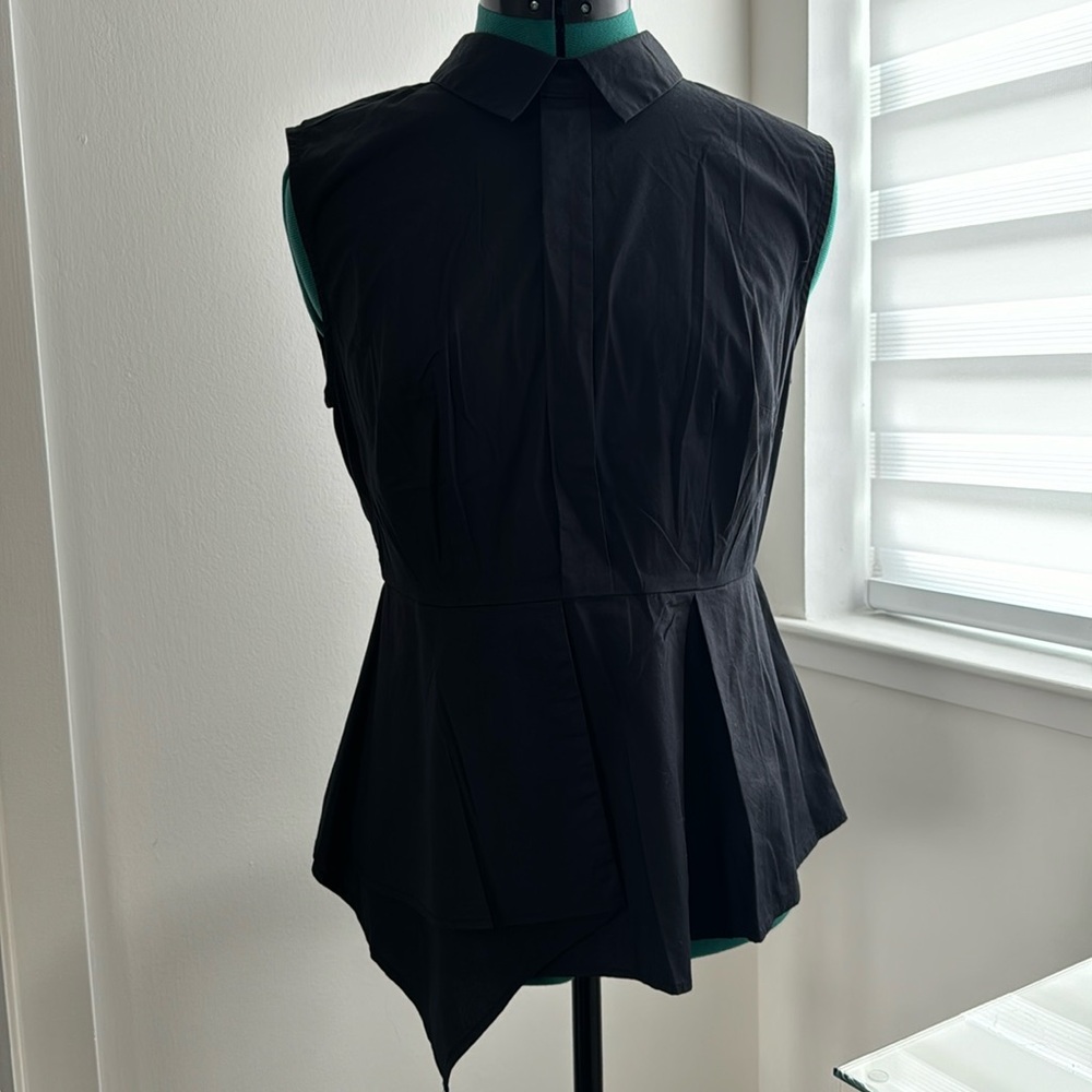Flattering collared sleeveless cotton blend top with asymmetrical hem.